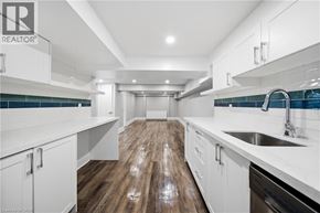 Toronto apartment for rent - A modern kitchen with white cabinets and a wooden floor.