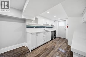 Toronto apartment for rent - A modern kitchen with white cabinets and a wooden floor.