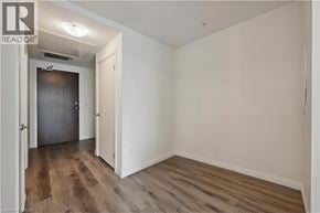 Kitchener condo for rent - A room with a wooden floor and white walls.