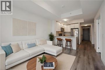 Kitchener condo for rent - A modern living room with a white sofa and a wooden coffee table.