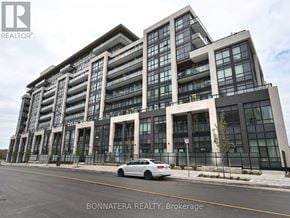 Oakville (Go Glenorchy) condo for rent - A modern multi-story building with a car parked in front.