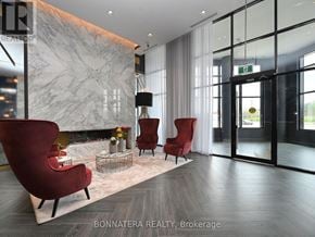 Oakville (Go Glenorchy) condo for rent - A modern living room with a marble fireplace and red chairs.