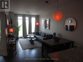 Toronto (Long Branch) condo for rent - A living room with a couch, a coffee table, and a mirror.