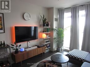 Toronto (Long Branch) condo for rent - A living room with a flat screen TV, a coffee table, and a potted plant.