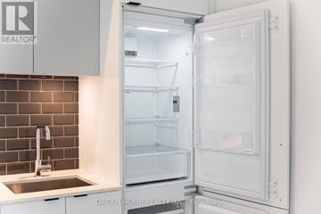 Toronto (South Parkdale) condo for rent - A white refrigerator is open in a kitchen.