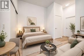 Toronto (South Parkdale) condo for rent - A bedroom with a bed, a chair, a table, and a couch.