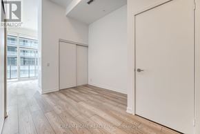 Toronto (South Parkdale) condo for rent - A room with a white door and a window with a view of a building outside.