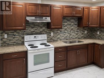 Brampton (Credit Valley) apartment for rent - A kitchen with a white stove top oven and brown cabinets.