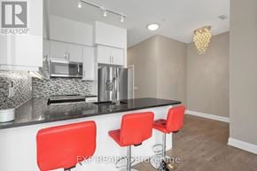 Toronto (Islington-City Centre West) condo for rent - A modern kitchen with white cabinets and a black countertop.
