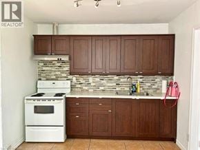 Hamilton apartment for rent - A kitchen with white appliances and brown cabinets.