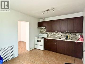 Hamilton apartment for rent - A kitchen with brown cabinets and a white dishwasher.