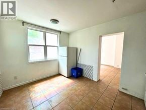 Hamilton apartment for rent - A room with a tiled floor, a window, and a door.