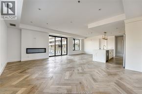 Tecumseh condo for rent - A spacious room with wooden flooring and a large window.