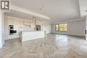 Tecumseh condo for rent - A spacious kitchen with a large island and a stainless steel refrigerator.