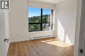 Coquitlam apartment for rent - A room with a large window overlooking a forest.