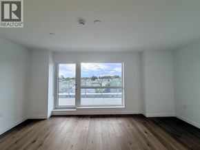 Vancouver apartment for rent - A large empty room with a window overlooking a cityscape.