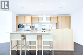 Vancouver apartment for rent - A modern kitchen with a white island and bar stools.