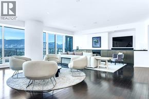 Vancouver apartment for rent - A living room with white furniture and a large window overlooking a snowy landscape.