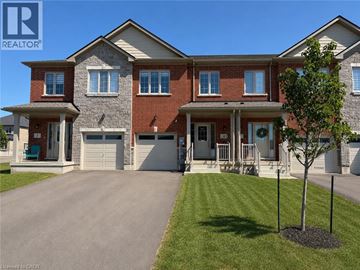 Thorold townhouse for rent - A large, two-story house with a garage and a driveway.