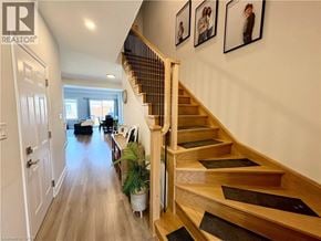 Thorold townhouse for rent - A wooden staircase with a black mat on the steps.