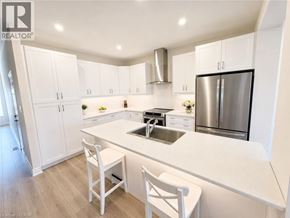 Thorold townhouse for rent - A modern kitchen with white cabinets and a stainless steel refrigerator.
