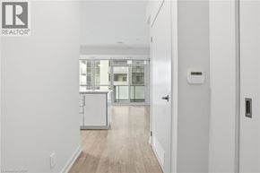 Burlington condo for rent - A white hallway with a door on the right and a kitchen in the background.