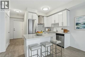 Burlington condo for rent - A modern kitchen with white cabinets and a center island.