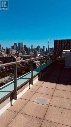Toronto (University) condo for rent - A balcony with a metal railing overlooking a city skyline.