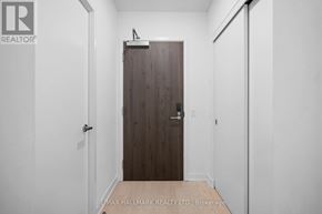Toronto (Church-Yonge Corridor) condo for rent - A hallway with a wooden door and white walls.