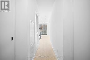 Toronto (Church-Yonge Corridor) condo for rent - A long hallway with white walls and wood floors.