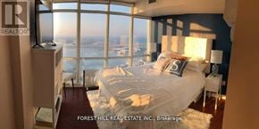 Toronto (Waterfront Communities) condo for rent - A bedroom with a large bed and a view of the city.