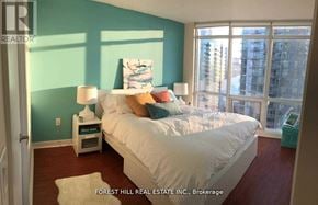 Toronto (Waterfront Communities) condo for rent - A bedroom with a large bed and a view of the city.