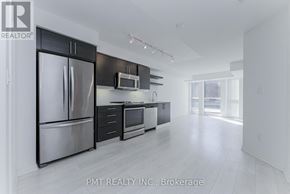 Toronto (Moss Park) condo for rent - A modern kitchen with stainless steel appliances and black cabinets.