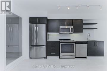 Toronto (Moss Park) condo for rent - A modern kitchen with a stainless steel refrigerator and black cabinets.