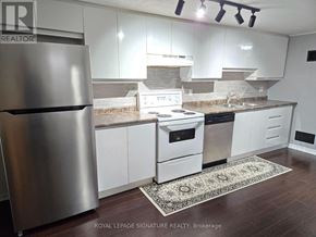 Mississauga (Clarkson) apartment for rent - A kitchen with white cabinets and a stainless steel refrigerator.