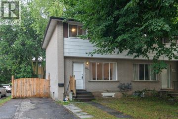 Waterloo apartment for rent - A house with a grey roof and a white door is surrounded by trees.