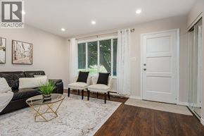 Waterloo apartment for rent - A living room with a black leather couch, a glass coffee table, and a white door.
