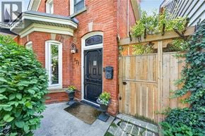 Hamilton apartment for rent - A red brick house with a black door and a wooden fence.
