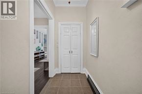 Hamilton apartment for rent - A hallway with a white door and a fridge in the background.
