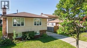 Windsor apartment for rent - A house with a brown roof and a white wall with windows and a tree in front.
