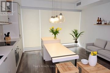 Toronto (Church-Yonge Corridor) condo for rent - A modern kitchen with a dining table and a couch.