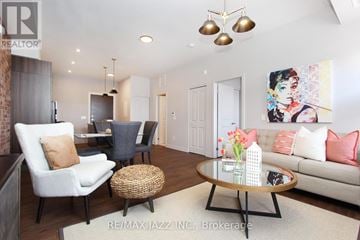 Oshawa (O'neill) multi-family for rent - A living room with a white couch, a coffee table, and a painting on the wall.