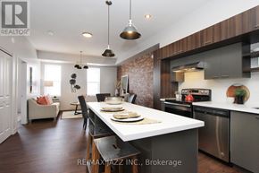 Oshawa (O'neill) multi-family for rent - A modern kitchen with a dining table set for two.