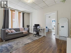 London apartment for rent - A living room with a grey couch and a wooden floor.
