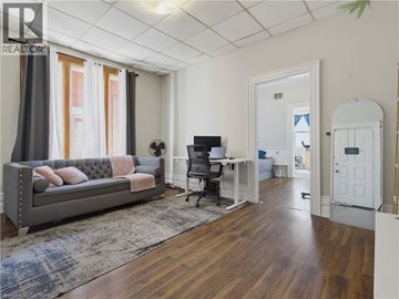 London apartment for rent - A living room with a grey couch and a wooden floor.