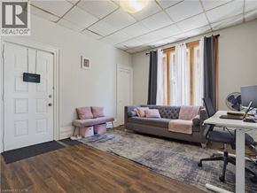 London apartment for rent - A living room with a grey couch, a pink chair, and a white desk.