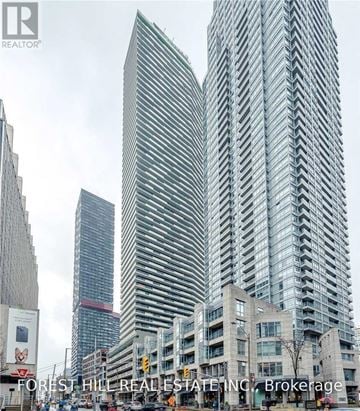 Toronto (Mount Pleasant West) condo for rent - A tall building with a curved facade stands in front of a smaller building.