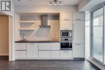 Toronto (Mount Pleasant West) condo for rent - A modern kitchen with white cabinets and stainless steel appliances.