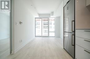 Toronto (Church-Yonge Corridor) condo for rent - A kitchen with a refrigerator and a view of a building outside.