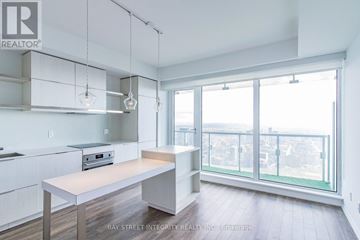 Toronto (Church-Yonge Corridor) condo for rent - A kitchen with white cabinets and a wooden island.